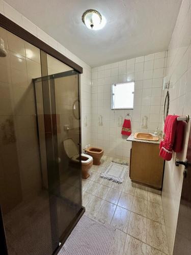 a bathroom with a shower and a toilet and a sink at Cantinho do Céu - Miguel Pereira in Miguel Pereira