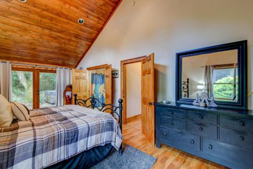 ein Schlafzimmer mit einem Bett und einer Kommode mit Spiegel in der Unterkunft Bigfoot Bungalow in Blowing Rock