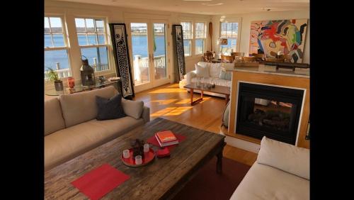 a living room with a couch and a fireplace at Oceanfront - Downtown in historic New England in Salem