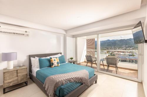 a bedroom with a bed and a balcony at Luxury 2-Bedroom Beachfront Oasis – Two Balconies to Soak in the Views in Puerto Vallarta