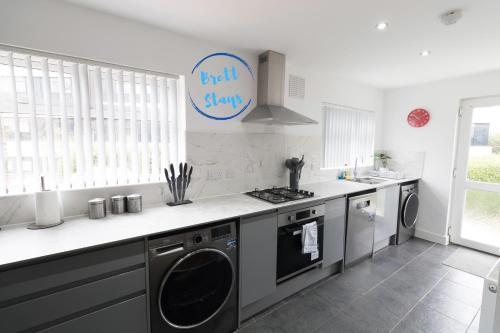 a kitchen with a washer and dryer in it at Newport 3 Bed Long Stay Van Parking M4 Access Sleeps 5 in Newport