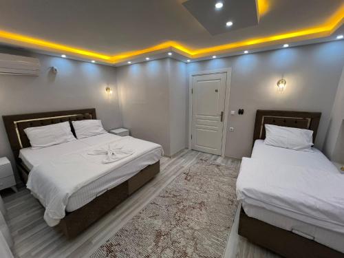 two beds in a room with white walls and lights at Sultanahmet Blue Suites in Istanbul