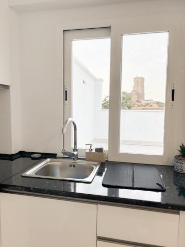 a kitchen counter with a sink and a window at Casa Puerta del Valle in Belalcázar