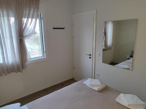 a white room with a mirror and a window at Ismini's Luxury Villas in Mirodháton
