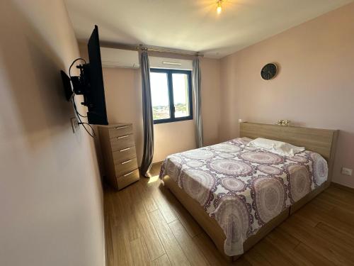 a bedroom with a bed and a flat screen tv at Pigonia T2 récent, confort et design à Furiani - à la nuitée in Furiani