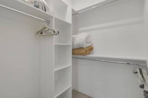 Elle comprend un dressing avec des murs blancs et une étagère. dans l'établissement Stylish Pasadena Stay Near Old Town & Rose Bowl, à East Pasadena