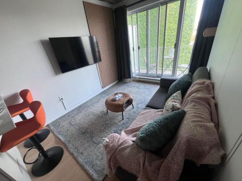 a living room with a couch and a television at Urban Hideout - Downtown Haven in Montréal
