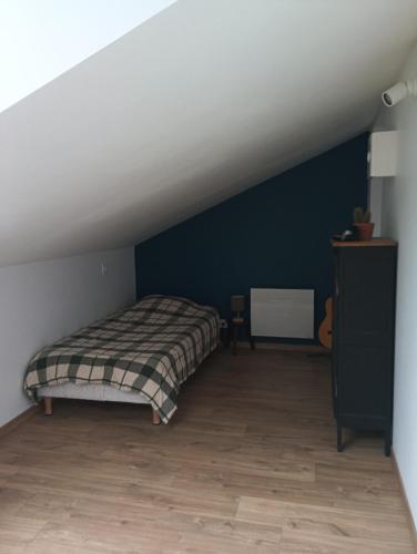 a bedroom with a bed in a attic at Chambre triple proche plage in Lancieux