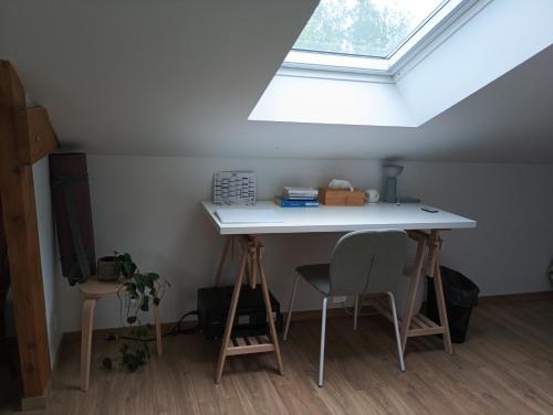 una mesa y 2 sillas en una habitación con tragaluz en Chambre triple proche plage, en Lancieux