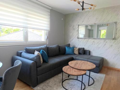 a living room with a blue couch and a table at Apartman Hedon in Vrnjačka Banja