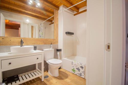 Un baño con lavabo, inodoro y espejo. en Las Natillas Con V - Martín Miguel, en Martín Miguel