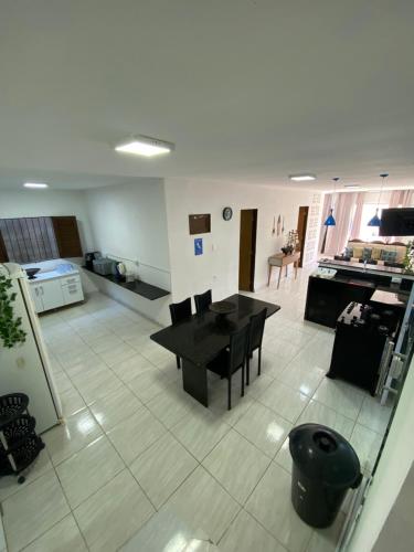 Una sala de estar con una mesa y una cocina. en Siqueira Beach house, en Tamandaré