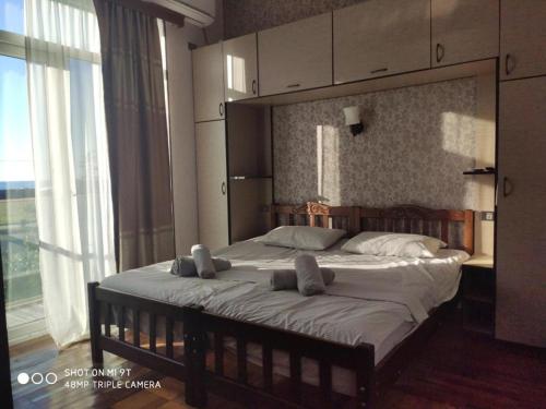 a bedroom with a large bed with two pillows on it at TIRKIUSTAS House in K'obulet'i