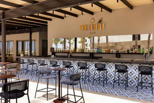 a bar at a restaurant with chairs and tables at Secrets Baby Beach Aruba Adults Only in Ceru Colorado