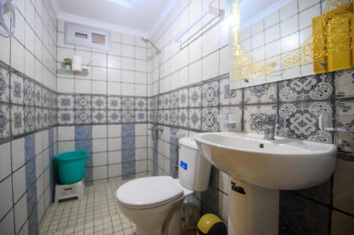 a bathroom with a white toilet and a sink at Dar Boukhari Luxury Stay in Chefchaouene