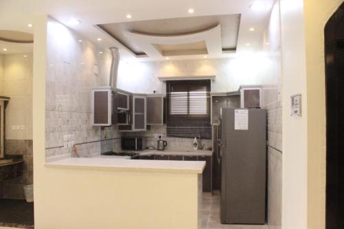 una cocina con nevera de acero inoxidable. en شاليهات ديم لايت, en Az Zulfi