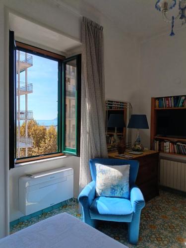 una camera da letto con una sedia blu e una finestra di Room with a view a Salerno