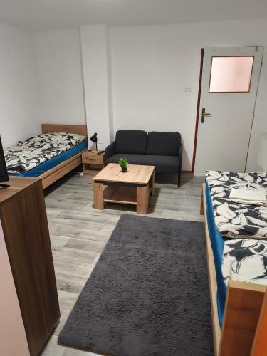 a room with two beds and a couch and a table at Ubytovanie Hrabiny in Sučany