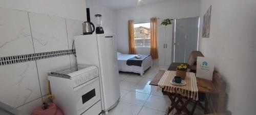 a kitchen with a refrigerator and a stove at Kitinet completa com varanda Praia de Caiobá in Matinhos