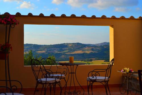 a patio with a table and chairs and a large window at Country Relais La Torretta Baronale in San Giorgio Montagna