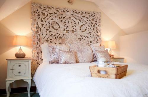 a bedroom with a large white bed with a wooden headboard at The Shepherd's Purse in Whitby