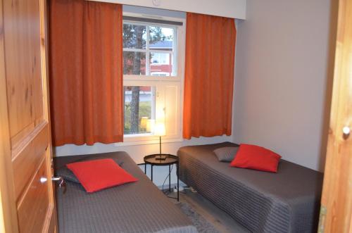 a small room with two beds and a window at Castillo Moitakuru in Saariselka