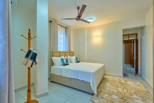 a bedroom with a bed and a ceiling fan at Royal Suites in Mombasa