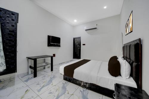 a white bedroom with a bed and a desk at Hotel O Choice Inn II in Rao