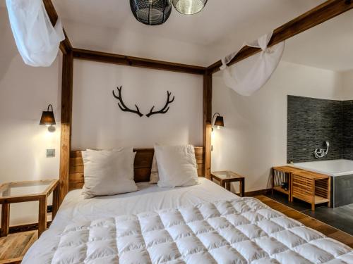 une chambre avec un lit avec des bois sur le mur dans l'établissement Appartement de prestige spacieux et lumineux avec sauna et parking inclus - FR-1-598-48, aux Gets