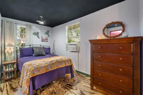 a bedroom with a bed and a dresser and a mirror at 1 Mile To Fsu-artsy Tree-house in Zion Hill