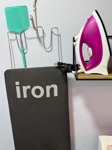 a iron hanging on a wall next to a sign at Artsy 2BR, Near FSU & Downtown in Tallahassee