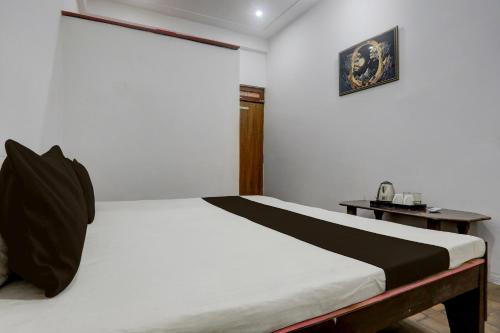 a bedroom with a bed and a table with a picture on the wall at SPOT ON S.M. HOTEL in Ghoghāpur