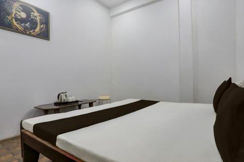 a bedroom with a bed and a table with a telephone at SPOT ON S.M. HOTEL in Ghoghāpur