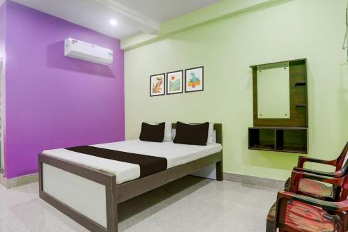 a bedroom with a bed and a purple wall at Hotel O SAI KRISHNA GUEST HOUSE in Kendrāparha