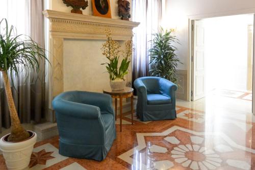a living room with two chairs and a fireplace at Hotel Santa Chiara in Venice