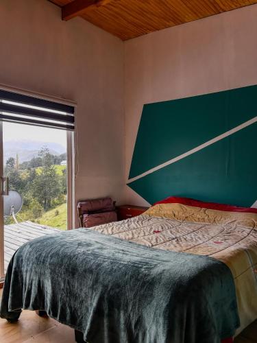 a bedroom with a large bed and a large window at refugio el bagual in Futaleufú