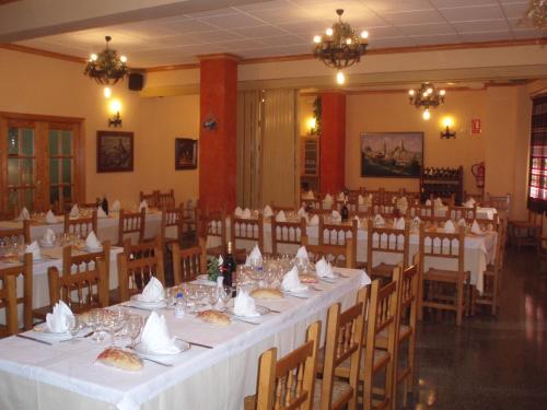 sala bankietowa z białymi stołami i krzesłami w obiekcie Hotel Mesón el Castillo w mieście Bañeres de Mariola