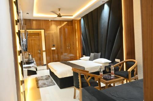 a hotel room with two beds and a table at Hotel Glumol in Roorkee