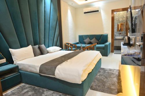 a bedroom with a bed and a blue wall at Hotel Glumol in Roorkee