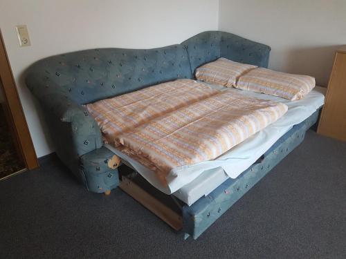 a bed in a room with a blue head board at Griesshof in Neustift im Stubaital