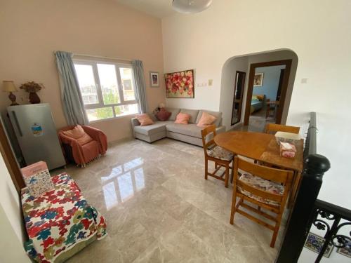 a living room with a table and a couch at Sunset Views in Muscat