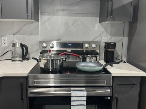 a kitchen with a stove with pots and pans on it at Modern comfort just 20 minutes from the airport, with a full kitchen in Edmonton