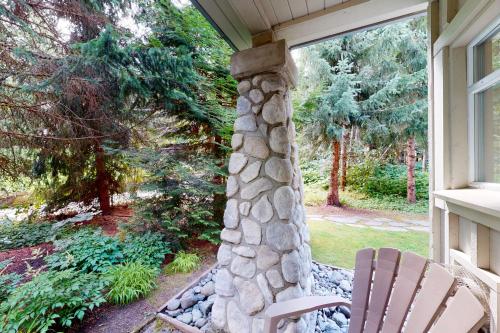 a porch with a stone pillar and two chairs at The Lagoons 27 in Whistler