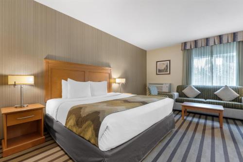 a hotel room with a bed and a couch at Best Western King George Inn & Suites in Surrey