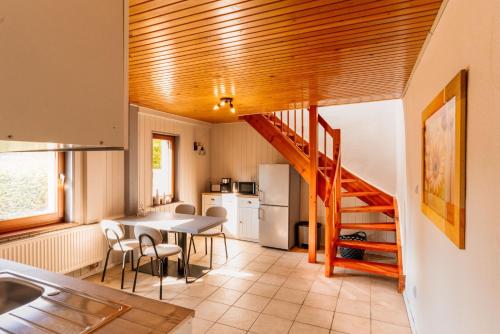 una cocina con escalera, mesa y sillas en Wohngefühl Appartements Bad Tabarz - Wohlfühlnest, en Tabarz