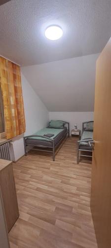 SpelleにあるFeWo Spelleのベッド2台が備わるウッドフロアの客室です。