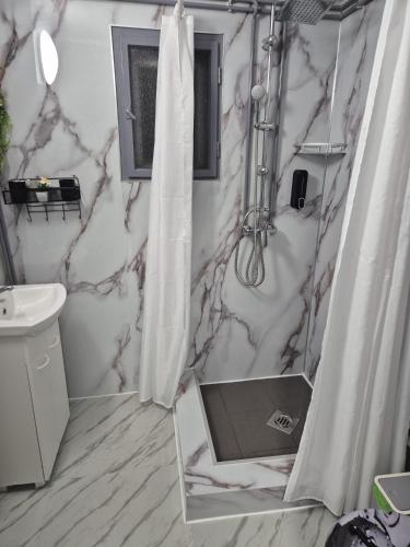 a bathroom with a shower curtain and a sink at Kucko Vendeghaz Guesthouse in Sárospatak