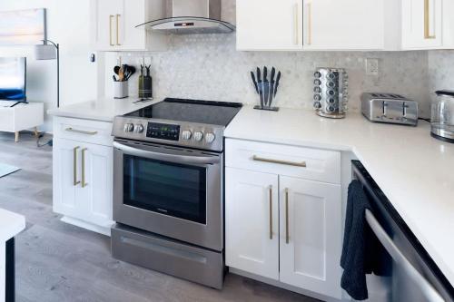 a kitchen with a stove and white cabinets at Manchaca Meadows Mini Villa Pool & Spa 20 min DT in Manchaca