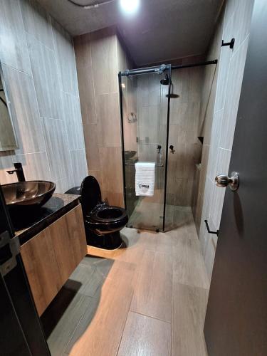 a bathroom with a toilet and a glass shower at Eureka Living in Bucaramanga