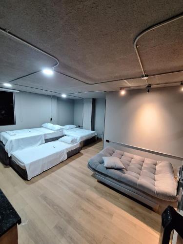 a room with two beds and a couch in it at Eureka Living in Bucaramanga
